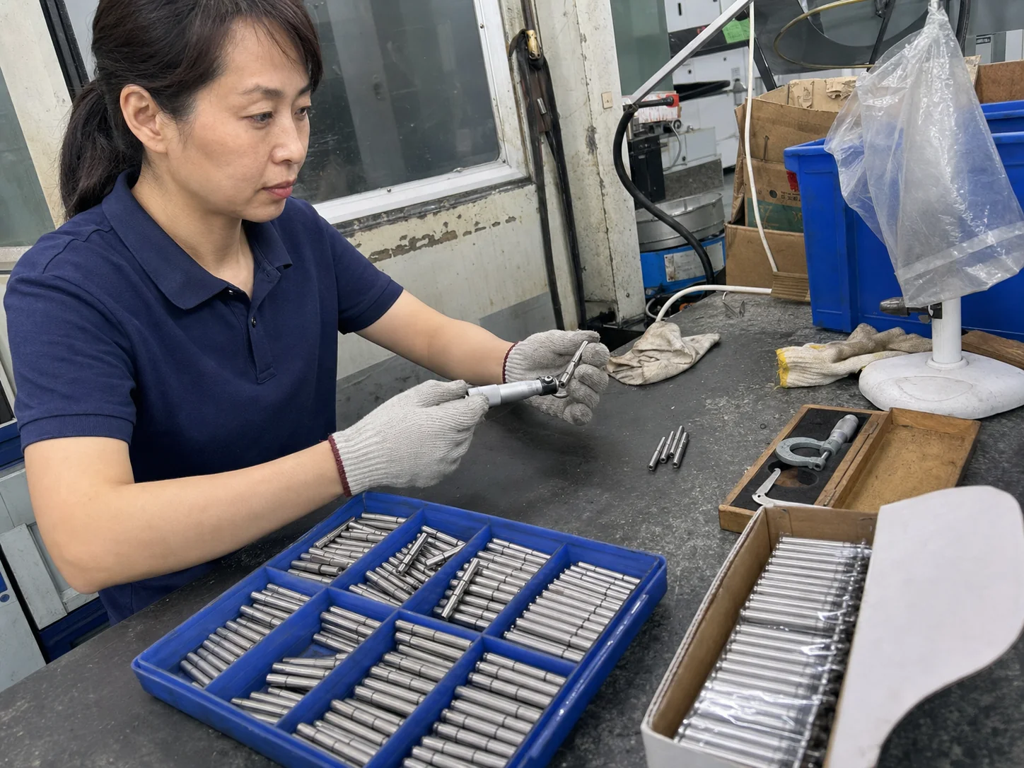 女性质量检验员在巡检台用千分尺复测SUS303定位销外径