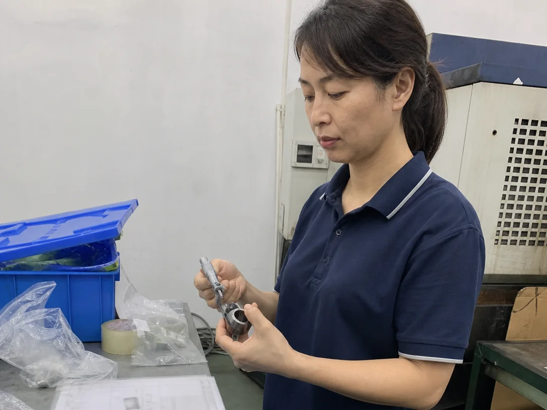 女性质量检验员在图纸评审台复测SUS304精密衬套内孔