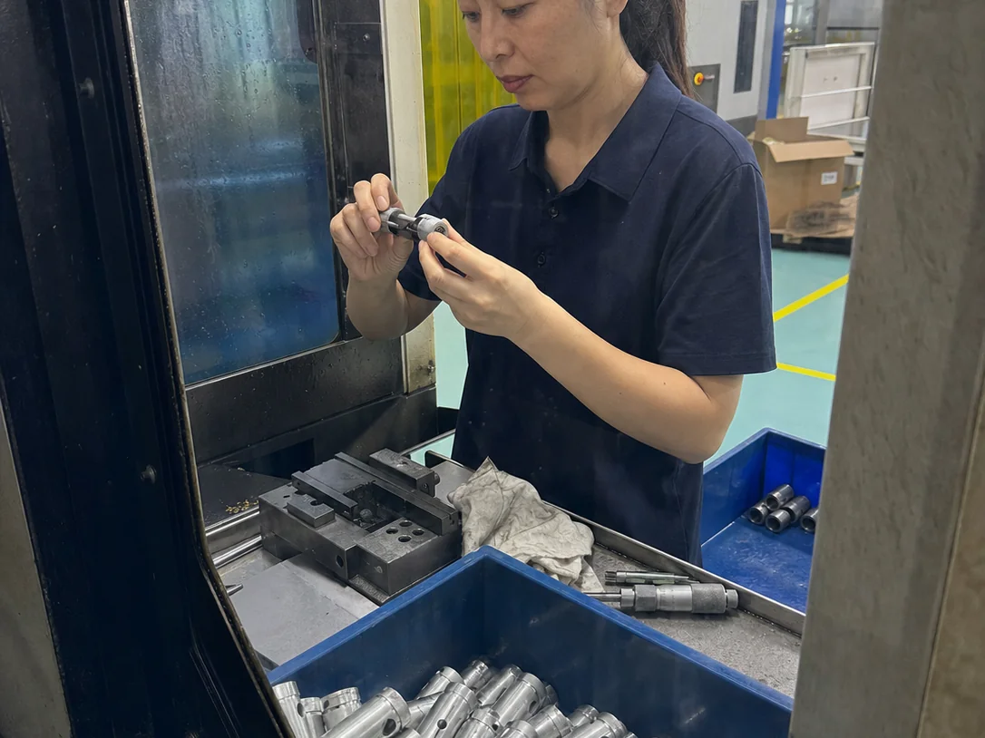 女性车间操作员在去毛刺工位复测7075铝合金精密套筒内外径