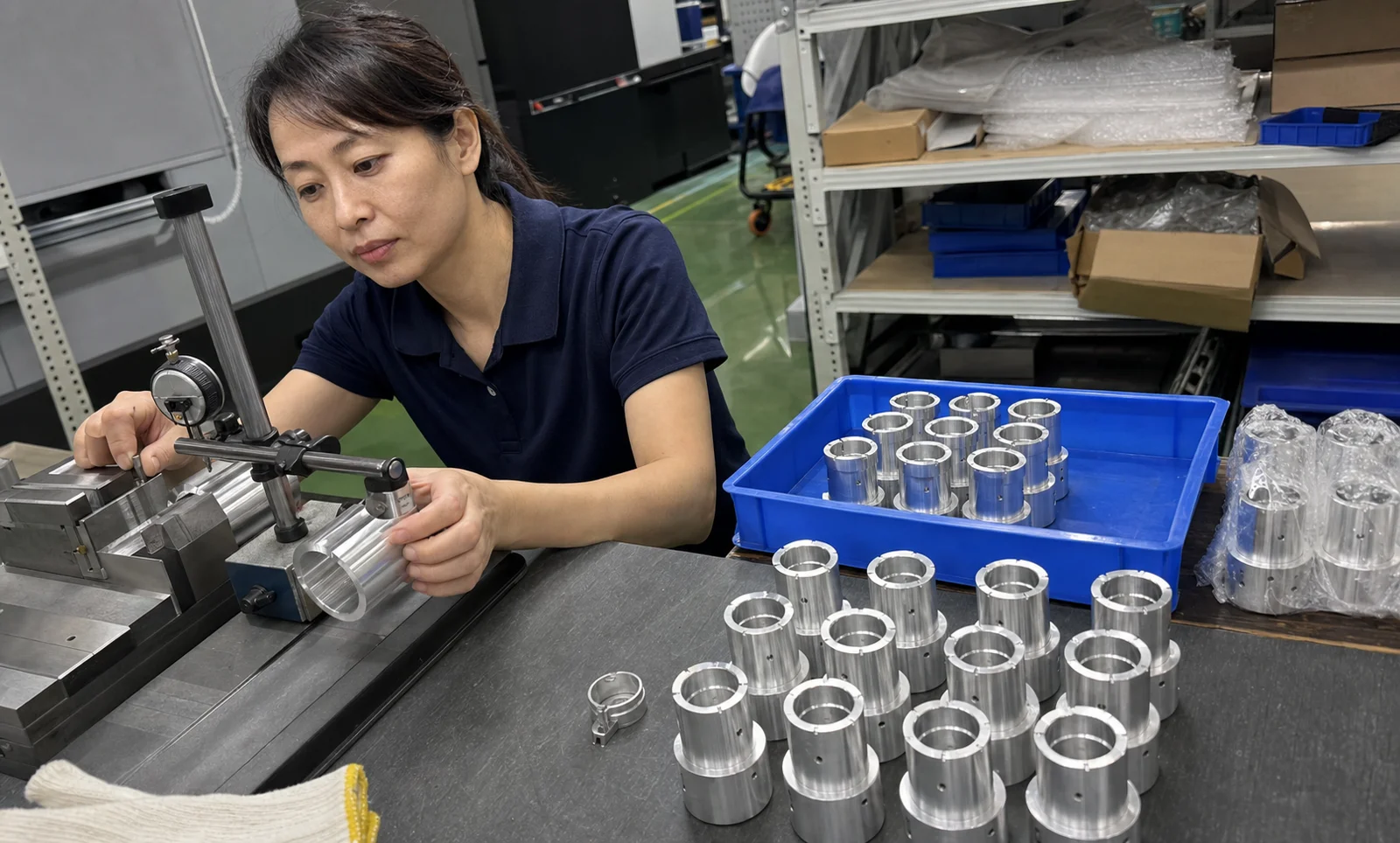 女性车间操作员在检验台核对铝合金套筒与软爪工装接触位置